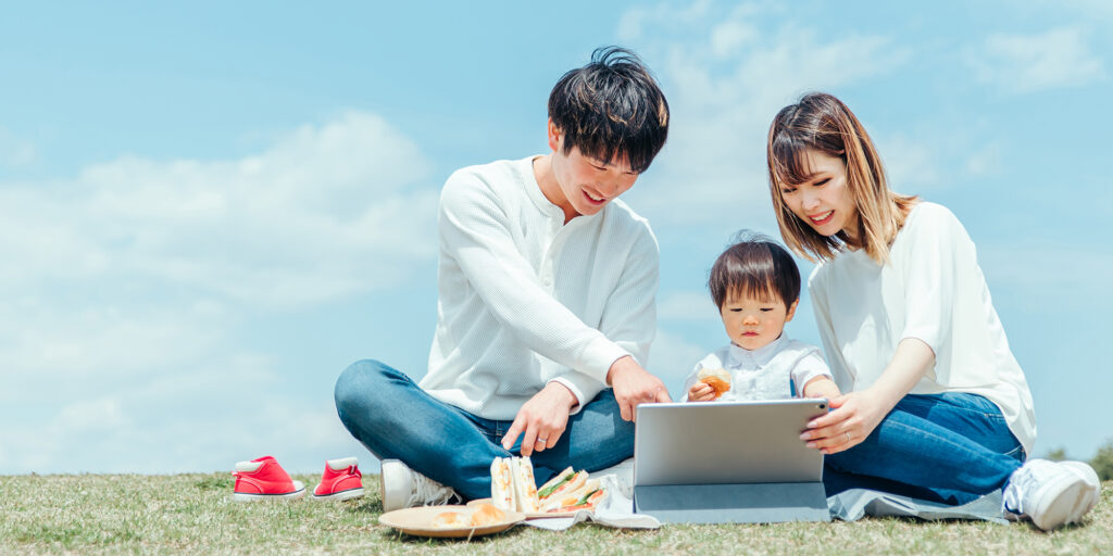 青空の下で動画編集されたビデオを見る家族