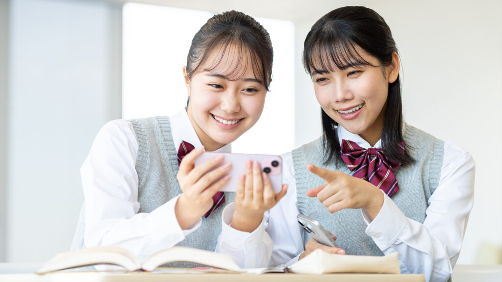 動画編集されたビデオを友達と見る女子高生