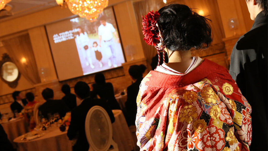 結婚式・記念日動画制作・ビデオ編集(プロフィールムービーを見る新郎新婦)